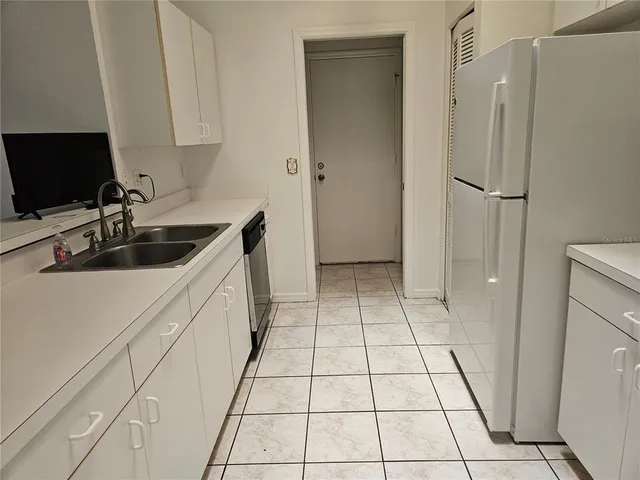 a kitchen with a refrigerator and a sink