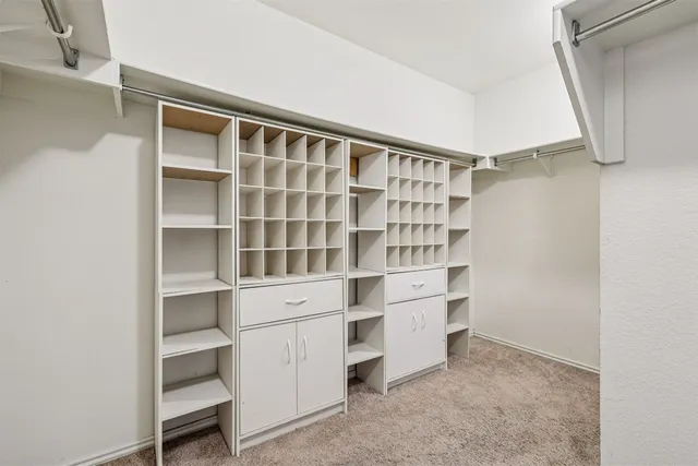 a view of walk in closet with empty racks