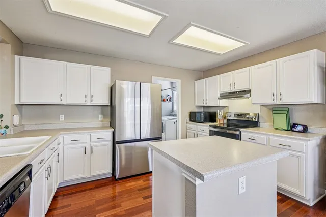 a kitchen with white cabinets and stainless steel appliances