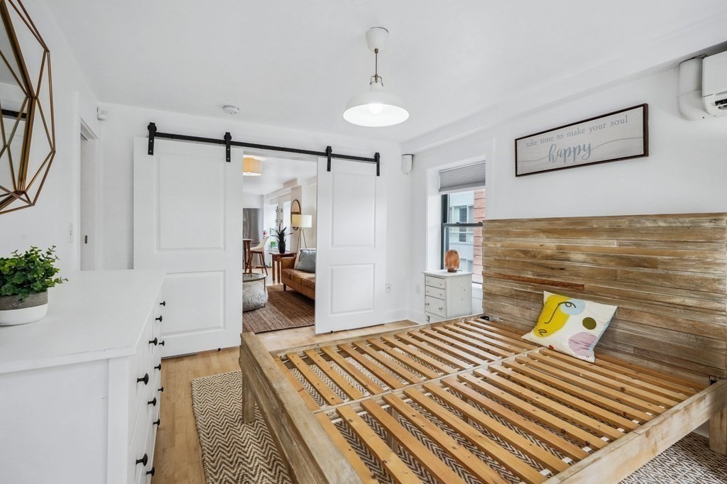 59 Fleet Street, Unit 3 Boston, MA 02109 - Photo 13 of 24 a bedroom with a bed and a chandelier