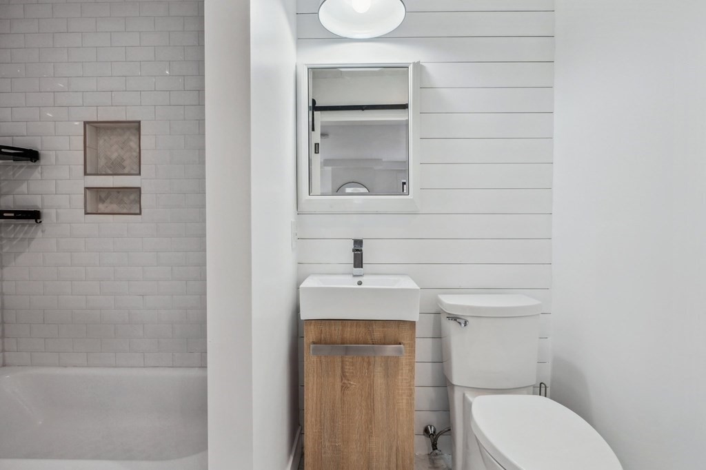 59 Fleet Street, Unit 3 Boston, MA 02109 - Photo 17 of 24 a bathroom with a toilet sink and mirror