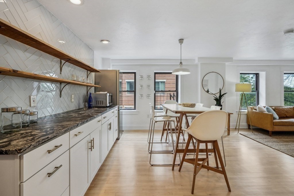 59 Fleet Street, Unit 3 Boston, MA 02109 - Photo 7 of 24 a large kitchen with sink a dining table and chairs