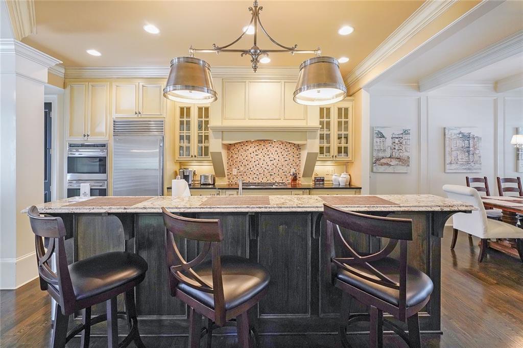 9062 Riverbend Manor Alpharetta, GA 30022 - Photo 6 of 36 a kitchen with a dining table chairs sink and wooden floor
