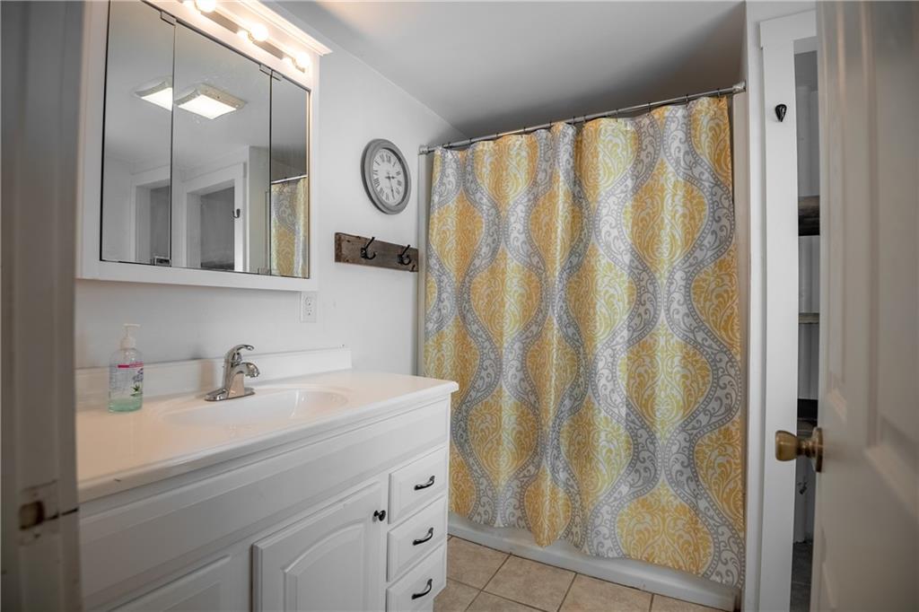 2042 Plain Grove Road Volant, PA 16156 - Photo 18 of 23 a bathroom with a sink a mirror and a shower curtain