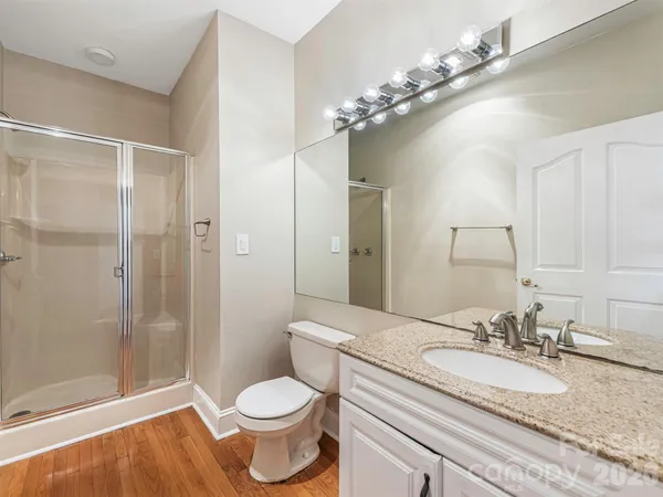 a bathroom with a granite countertop sink a toilet and shower