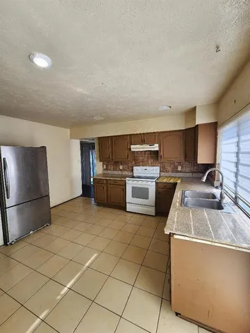 a kitchen with stainless steel appliances granite countertop a refrigerator sink and stove