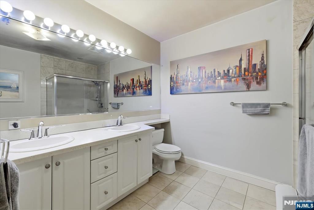 214 The Promenade, Unit 214 Edgewater, NJ 07020 - Photo 22 of 36 a bathroom with a toilet sink and mirror