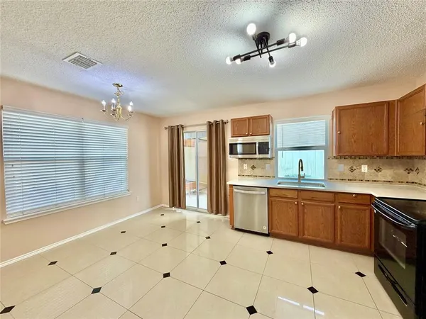 a kitchen with granite countertop a stove sink and cabinets
