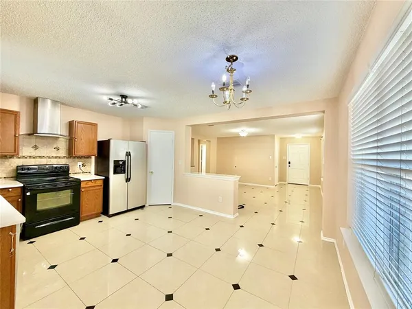 a large white kitchen with kitchen island stainless steel appliances view refrigerator and cabinets