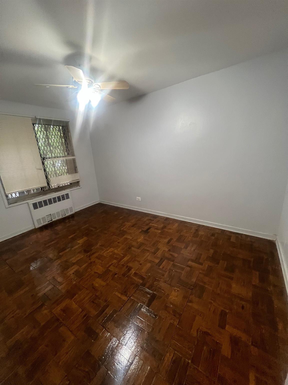 285 East 35th Street, Unit 2D Brooklyn, NY 11203 - Photo 5 of 21 Unfurnished room with ceiling fan and radiator