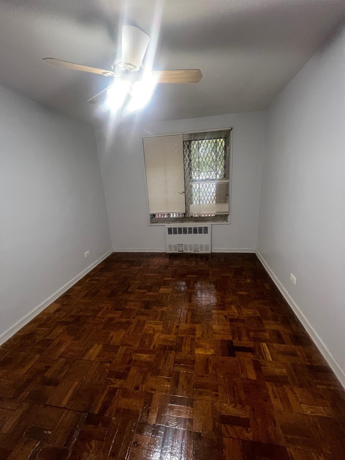 285 East 35th Street, Unit 2D Brooklyn, NY 11203 - Photo 6 of 21 Unfurnished room featuring a ceiling fan and radiator heating unit