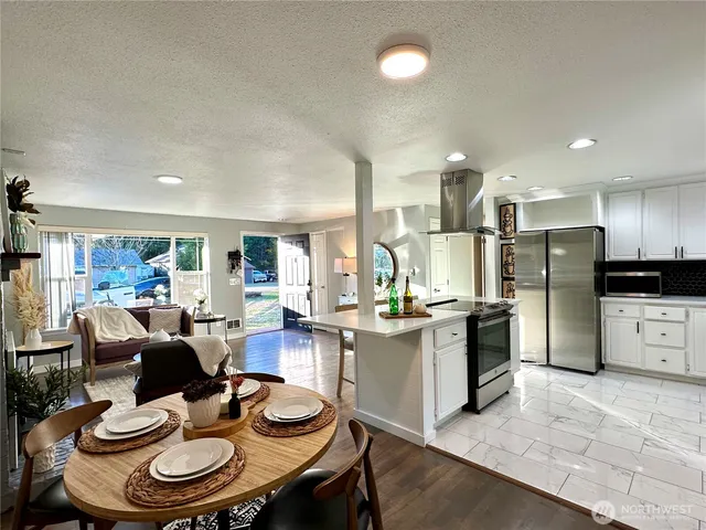 a kitchen with refrigerator and chairs