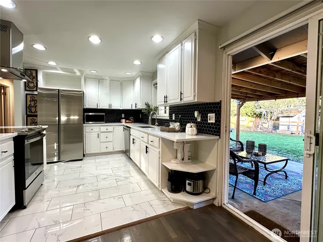 a kitchen with stainless steel appliances kitchen island granite countertop a stove a sink and a microwave