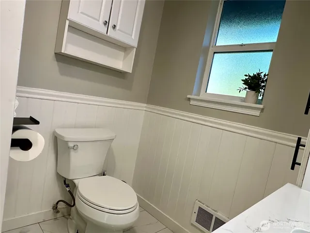 a white toilet sitting next to a window