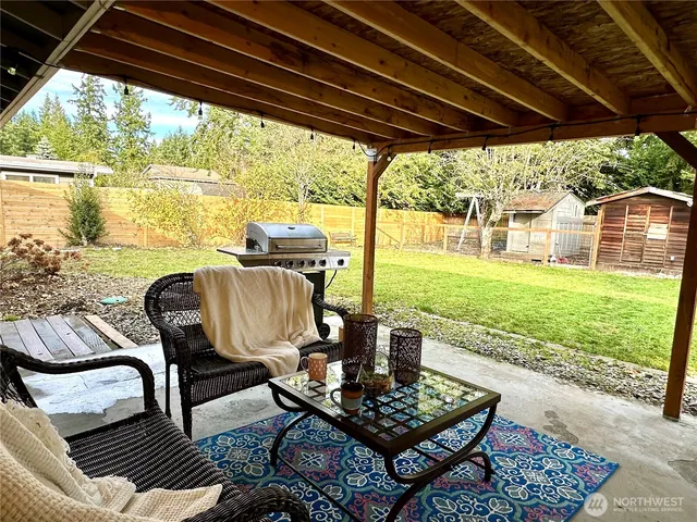 a view of a porch with furniture and a yard