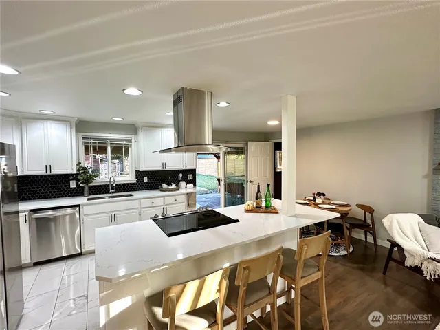 a kitchen with a sink a stove and chairs