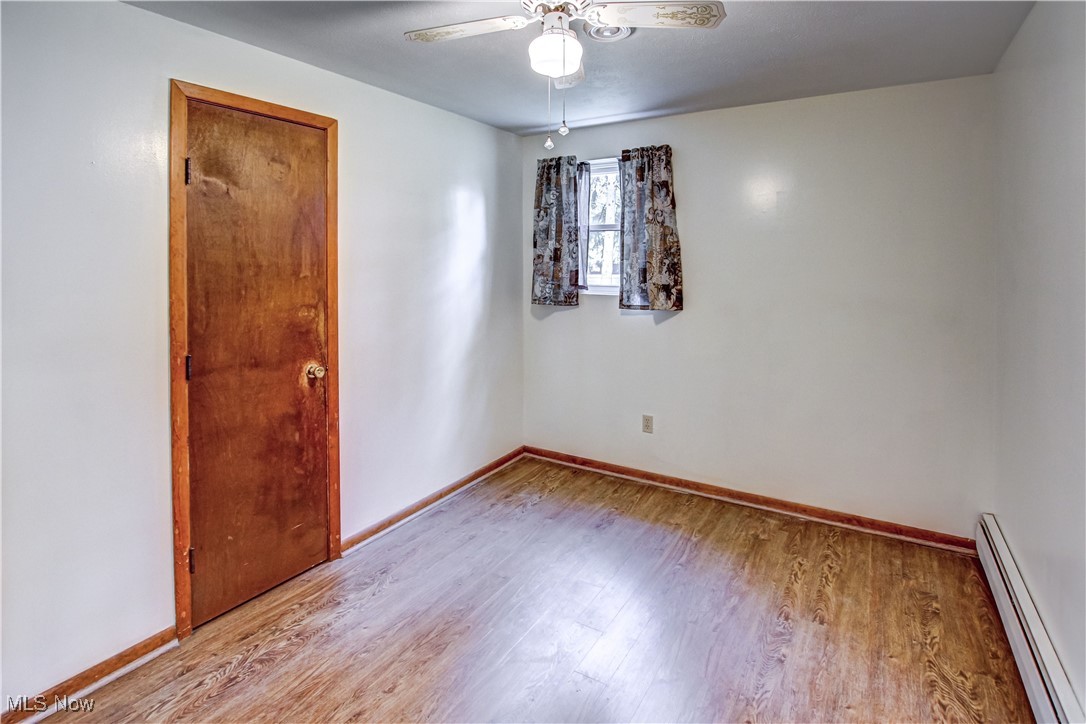 706 Abbe Road South Elyria, OH 44035 - Photo 22 of 34 Bedroom featuring baseboard heating, light wood finished laminate floors, and ceiling fan