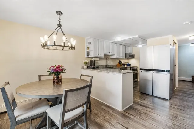 a kitchen with a dining table chairs refrigerator and microwave