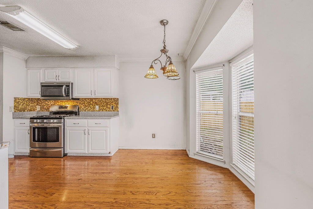 53 4th Street Shalimar, FL 32579 - Photo 10 of 47 a kitchen with stainless steel appliances a white cabinets and a wooden floor