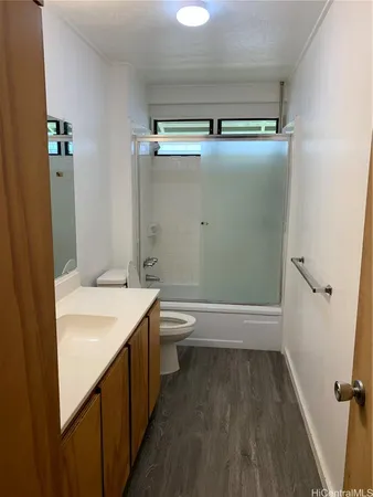 a bathroom with a granite countertop bathtub shower sink vanity and toilet