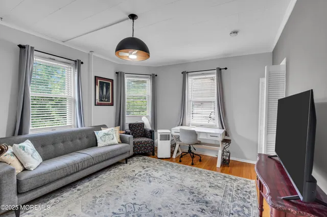 a living room with furniture flat screen tv and a large window