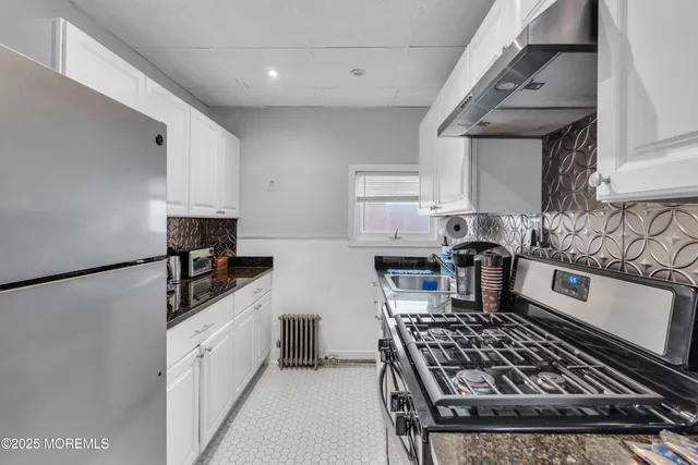 a kitchen with granite countertop a sink stove and refrigerator