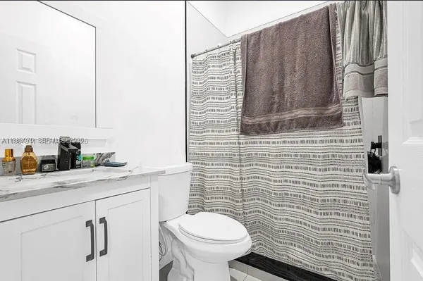 a bathroom with a granite countertop toilet sink and mirror