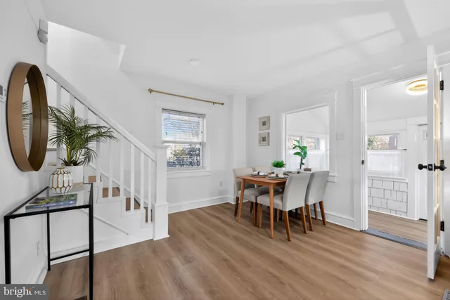 a dining room with furniture entryway and wooden floor