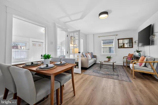 a living room with furniture kitchen view and a flat screen tv
