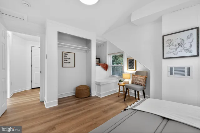 a view of a livingroom with wooden floor and a workspace