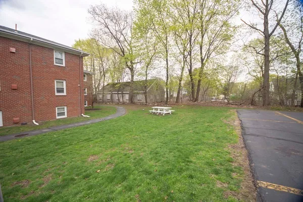 a view of a house with backyard and a tree