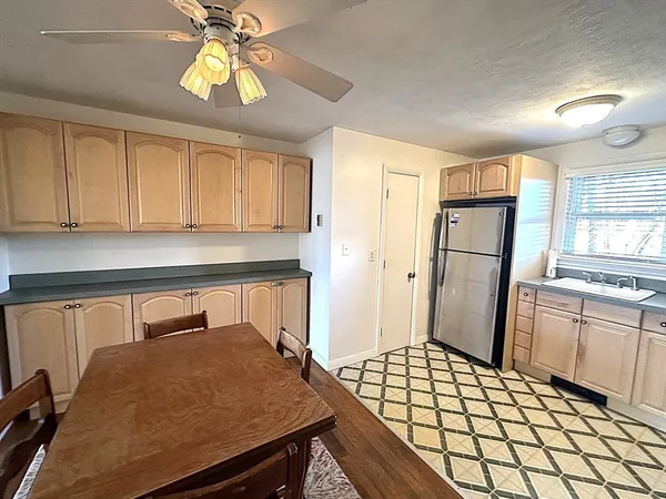 a kitchen with a table chairs refrigerator and cabinets