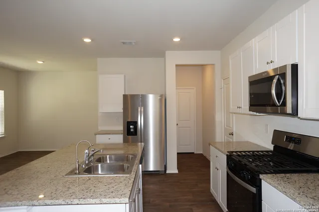 a kitchen with stainless steel appliances granite countertop a refrigerator and a stove top oven
