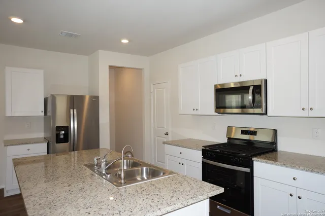 a kitchen with granite countertop a stove and a sink