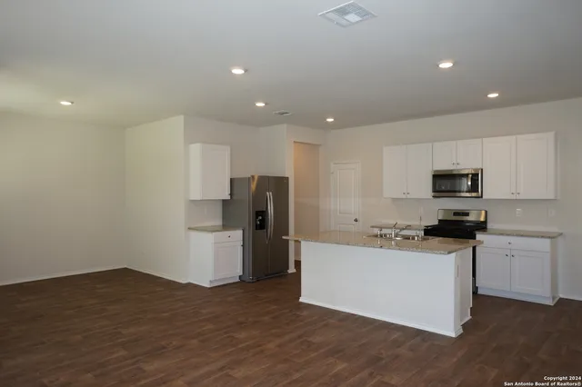 a kitchen with stainless steel appliances a refrigerator and a stove top oven