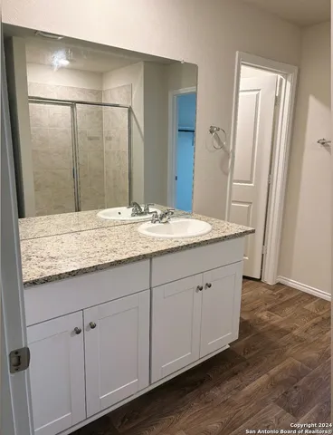 a bathroom with a granite countertop sink and mirror