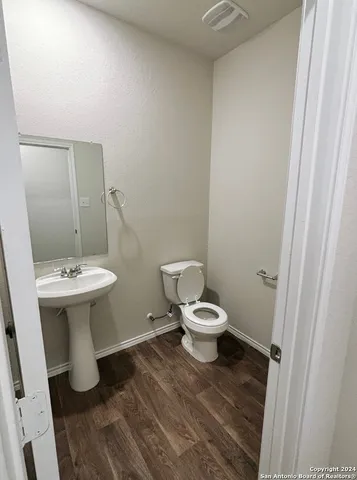 a bathroom with a sink toilet and a mirror