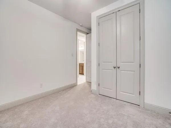 an empty room with a windows and cabinet