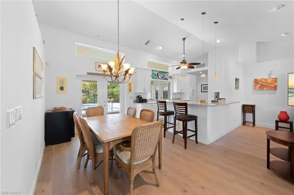 a view of a dining room and livingroom with furniture wooden floor a chandelier