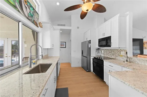 a kitchen with stainless steel appliances granite countertop a sink and a refrigerator