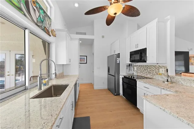 a kitchen with stainless steel appliances granite countertop a sink and a refrigerator