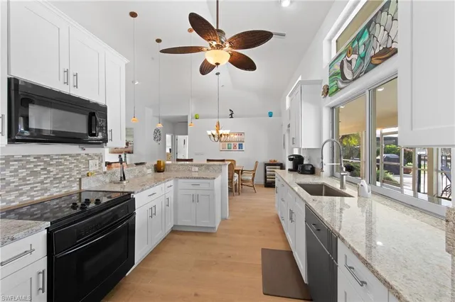 a large kitchen with stainless steel appliances granite countertop a stove and a sink
