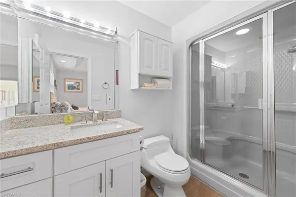 a bathroom with a granite countertop sink toilet and shower