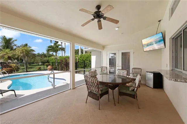 a dining room with furniture a chandelier and a large window