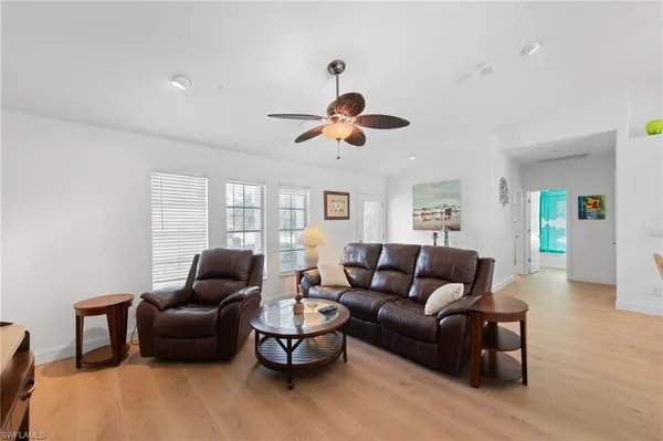 a living room with furniture ceiling fan and a window