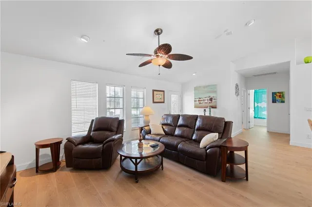 a living room with furniture ceiling fan and a window