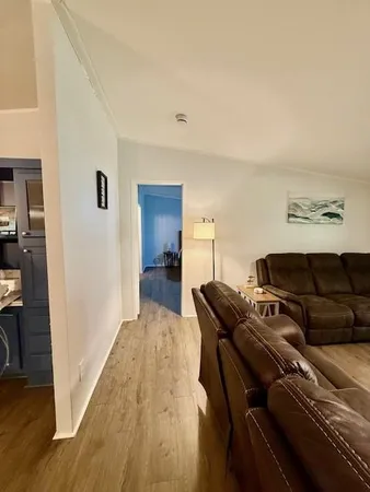 a view of a hallway with wooden floor and furniture