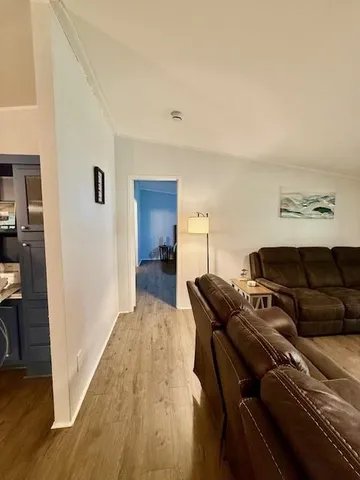 a view of a hallway with wooden floor and furniture