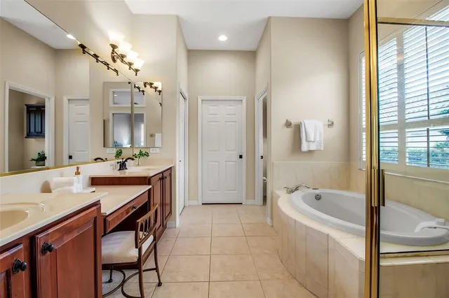 a bathroom with a tub a sink a mirror and a shower