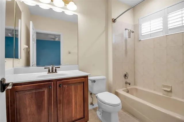 a bathroom with a granite countertop sink toilet mirror and bathtub